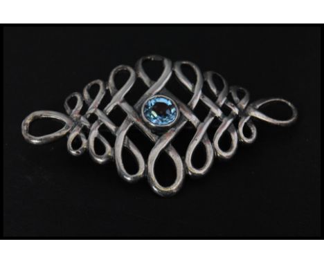 A vintage 925 silver brooch pin set with a blue stone, possibly topaz, having a roller clip clasp. Marked 925. Measures 5cms.