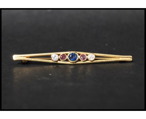 An 18ct gold 5 stone bar brooch being set with a central blue sapphire flanked by two pink sapphires and two white stones hav