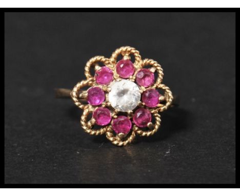 A hallmarked 9ct gold ruby and white stone cluster ring. Hallmarked London. Size S. Weight 3.4g.