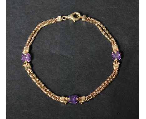 A hallmarked 9ct gold and amethyst bracelet having prong set fancy cut amethyst on a  twin chain. Hallmarked Sheffield. Measu