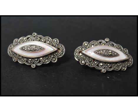 A vintage pair of 925 silver large clip-on earrings decorated with marcasite and mother of pearl. Marked 925 to clip and body