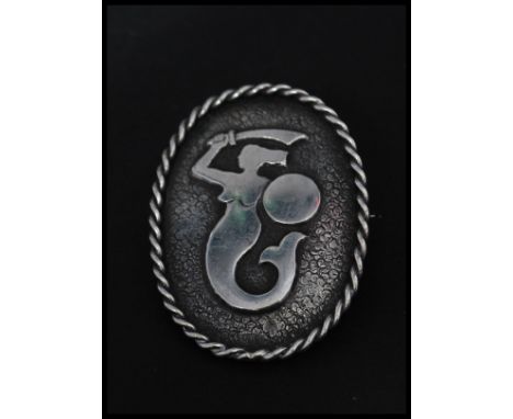 A vintage hallmarked silver brooch pin with figural mermaid motif with roller clip clasp and rope twist border. Marks for Pol