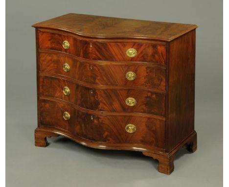 A George III mahogany serpentine fronted chest of drawers, with crossbanded edge above four long graduated drawers with brass