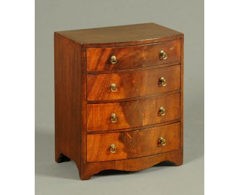 An early 19th century mahogany miniature bowfronted chest of drawers, four drawers with brass handles, with shaped apron and 