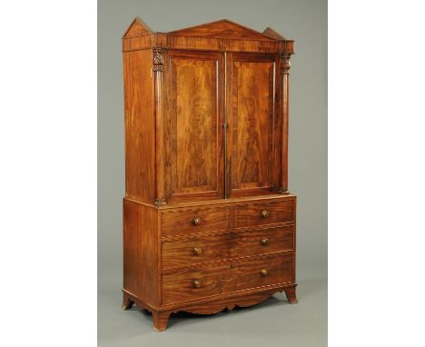 A William IV mahogany gentleman's press, with pair of panelled doors enclosing pullout trays, the base fitted with two short 