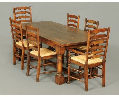 An oak refectory table, with heavy top supported by a recessed frieze and four turned legs united by a centre and end stretch