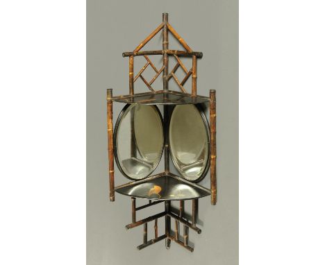 An Edwardian bamboo and lacquered corner hanging mirrored and shelved bracket.  Height 94 cm. 
