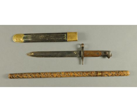 A First World War bayonet, with leather and brass mounted scabbard, length 40 cm, and a Victorian sword stick with wooden car