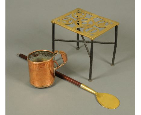 A Victorian brass and iron trivet, a mahogany handled long spoon and a copper measure.  Trivet width 29 cm. 