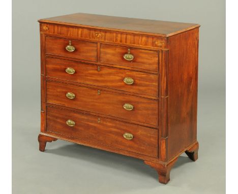 An early 19th century mahogany chest of drawers, with rectangular top above a crossbanded frieze and with two short and three