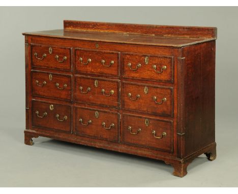 An early 19th century oak and mahogany crossbanded Lancashire mule chest, fitted with a series of drawers and dummy drawers w
