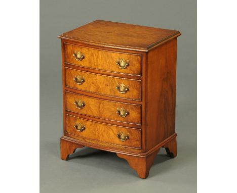A small reproduction walnut veneered chest of four drawers, with brass drop handles and raised on bracket feet.  Width 45 cm.