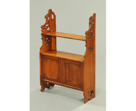 An Edwardian walnut wall mounting combined shelf and cupboard unit, with fretwork carved side.  Width 59 cm. 