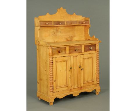A Victorian Scottish pine kitchen dresser, fitted with a series of drawers and cupboards, flanked by half round turned mouldi