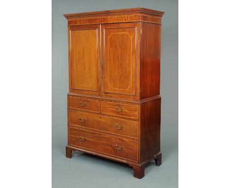 An Edwardian inlaid mahogany linen press, with moulded dentil cornice above a crossbanded frieze and pair of panelled cupboar