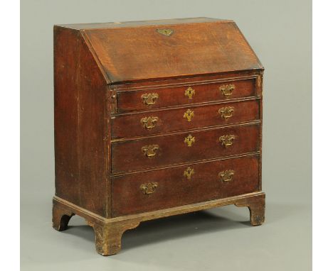 A George III oak bureau, with slope front to fitted interior, four long graduated drawers with brass drop handles and lock es
