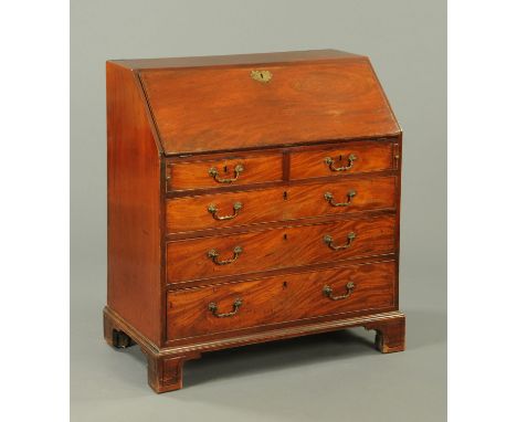 A George III mahogany bureau, with slope front to fitted interior above two short and three long graduated drawers with brass