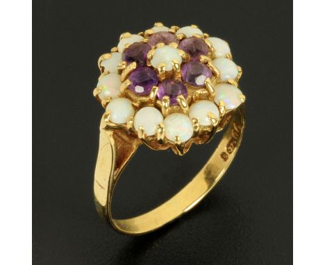 A 9 ct gold opal and amethyst ring, size N.  CONDITION REPORT: Generally in good order but one of the opals has a chip and wo