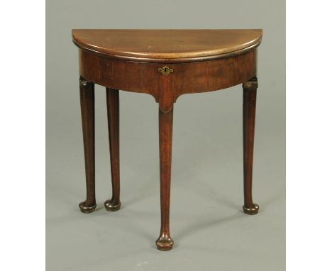 A George III mahogany turnover top demi-lune table, raised on four turned legs terminating in pad feet.  Width 69 cm.  CONDIT