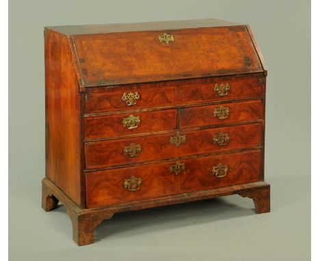 A George III walnut bureau, with slope front to fitted interior with well and with one dummy, two short and two long drawers 