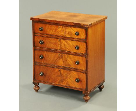 An early 19th century mahogany commode chest of drawers, the front modelled as four drawers with wooden knob handles and rais