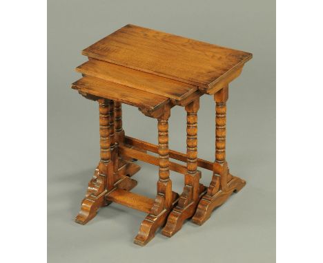 An oak nest of three tables, each with bobbin turned legs.  Largest width 49.5 cm. 