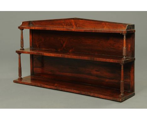 A William IV mahogany three tier hanging shelf unit, with triangular pediment and turned columns between each shelf.  Width 1