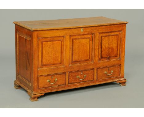 A George III oak mule chest, with lift up top, three panelled front, three drawers and raised on short bracket feet.  Width 1