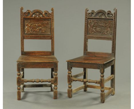 A pair of antique oak occasional chairs, each carved with a hunting scene to the back panel and raised on turned front legs.