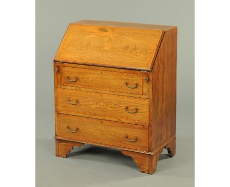 An Edwardian inlaid mahogany bureau, with slope front inlaid with a vase and foliate scrollwork and with three graduated draw