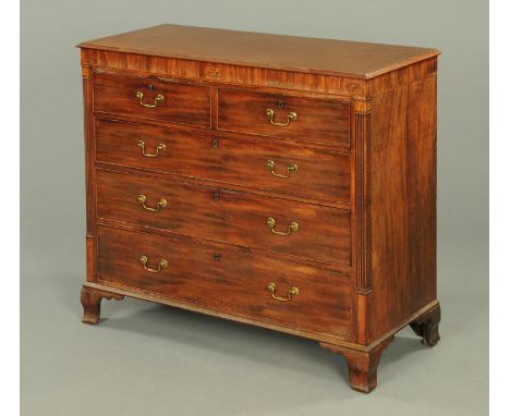 A George III mahogany chest of drawers, with two short and three long graduated drawers with brass drop handles, flanked by c