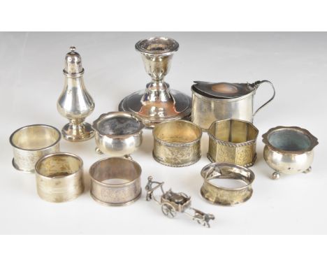 Hallmarked silver items comprising six various napkin rings, pair of salts raised on ball feet, mustard, pepper and a candles