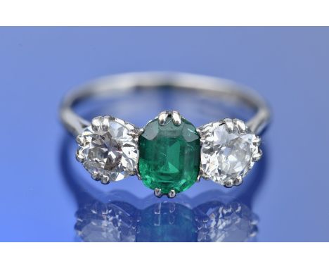 A platinum ring set with an emerald cut emerald of approximately 1.1ct and two old cut diamonds of approximately 0.8ct each, 