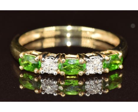 A 9ct gold ring set with green garnets and diamonds, 2.1g, size S