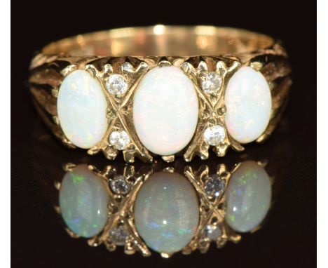 A 9ct gold ring set with three oval cut opal cabochons and four diamonds, 3.5g, size P