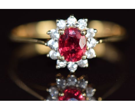 A 9k gold ring set with an oval cut Malawi ruby of approximately 0.4ct surrounded by zircons, 1.6g, size N