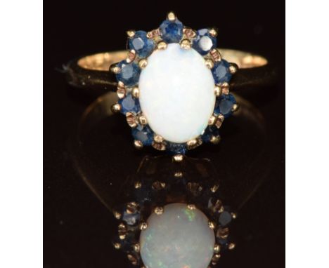 A 9ct gold ring set with an opal surrounded by sapphires, 4.1g, size P