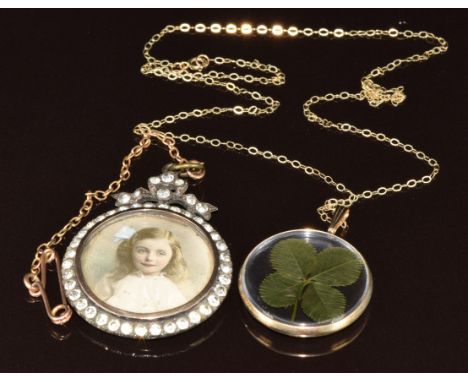 A 9ct gold pendant set with a four leaf clover and an Edwardian silver locket set with paste and a photographs (3.1 x 4cm)