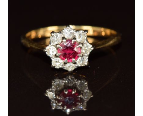An 18ct gold ring set with a round cut ruby surrounded by diamonds, 2.3g, size N