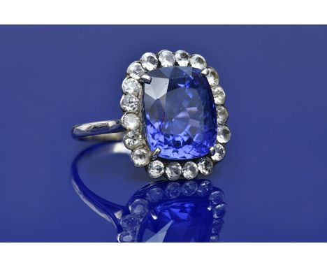 A 14k white gold ring set with a natural cushion cut purple-blue colour change Ceylon sapphire of approximately 10ct surround