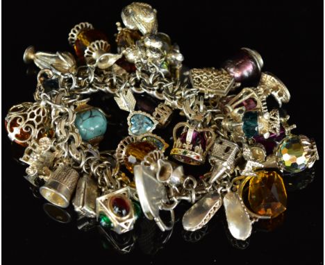 A silver charm bracelet with twenty seven silver charms including crystal set, dog, camera, etc , 189g&nbsp;