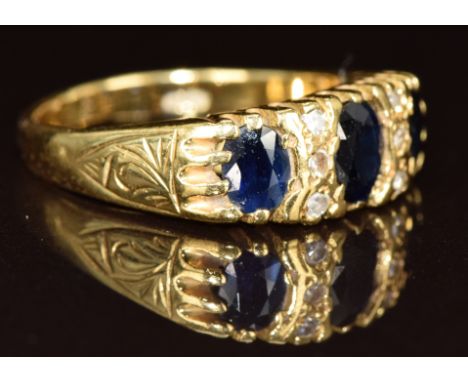 An 18ct gold ring set with three oval cut sapphires and six diamonds, 5.3g, size N