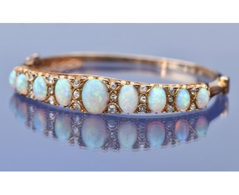 An 18ct gold Victorian bangle set with nine graduated oval opal cabochons (largest opal 1.2ct, smallest opal 0.4ct) and twent