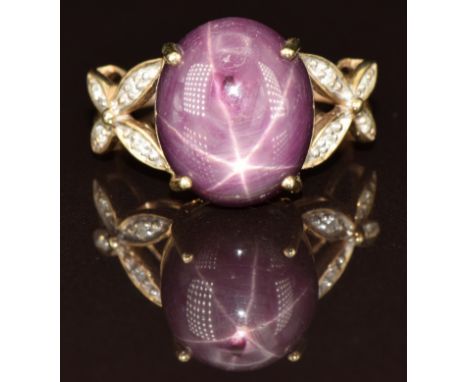 A 9k gold ring set with a star ruby cabochon and diamonds, 3.9g, size L
