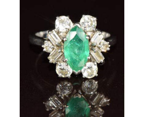 An 18ct white gold ring set with a marquise cut emerald of approximately 1ct surrounded by round and baguette cut diamonds to
