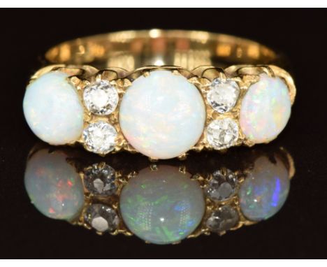 A c1910 18ct gold ring set with three round opal cabochons and four old cut diamonds, each diamond approximately 0.07ct, 4g, 