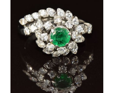 An 18k white gold ring set with an emerald of approximately 0.5ct surrounded by diamonds, 5.9g, size I
