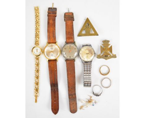 Three silver rings including one set with emeralds, two pairs of 9ct gold earrings, two military badges, Felca watch, Sekonda