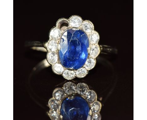 An 18ct white gold ring set with an oval cut sapphire of approximately 1ct&nbsp;surrounded by diamonds, each approximately 0.