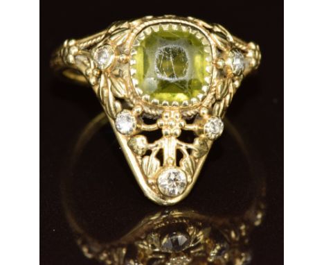 Arts &amp; Crafts yellow metal ring set with a cushion cut peridot and diamonds in a pierced setting, 5g, size K
